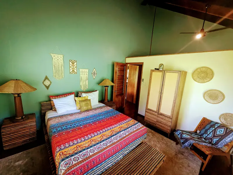 Bedroom with a striped bedspread and timber floors